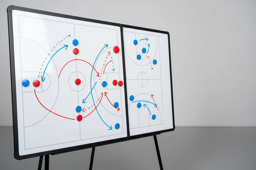 Professional white basketball coaching strategy board with red and blue magnetic markers and dry-erase tactical lines